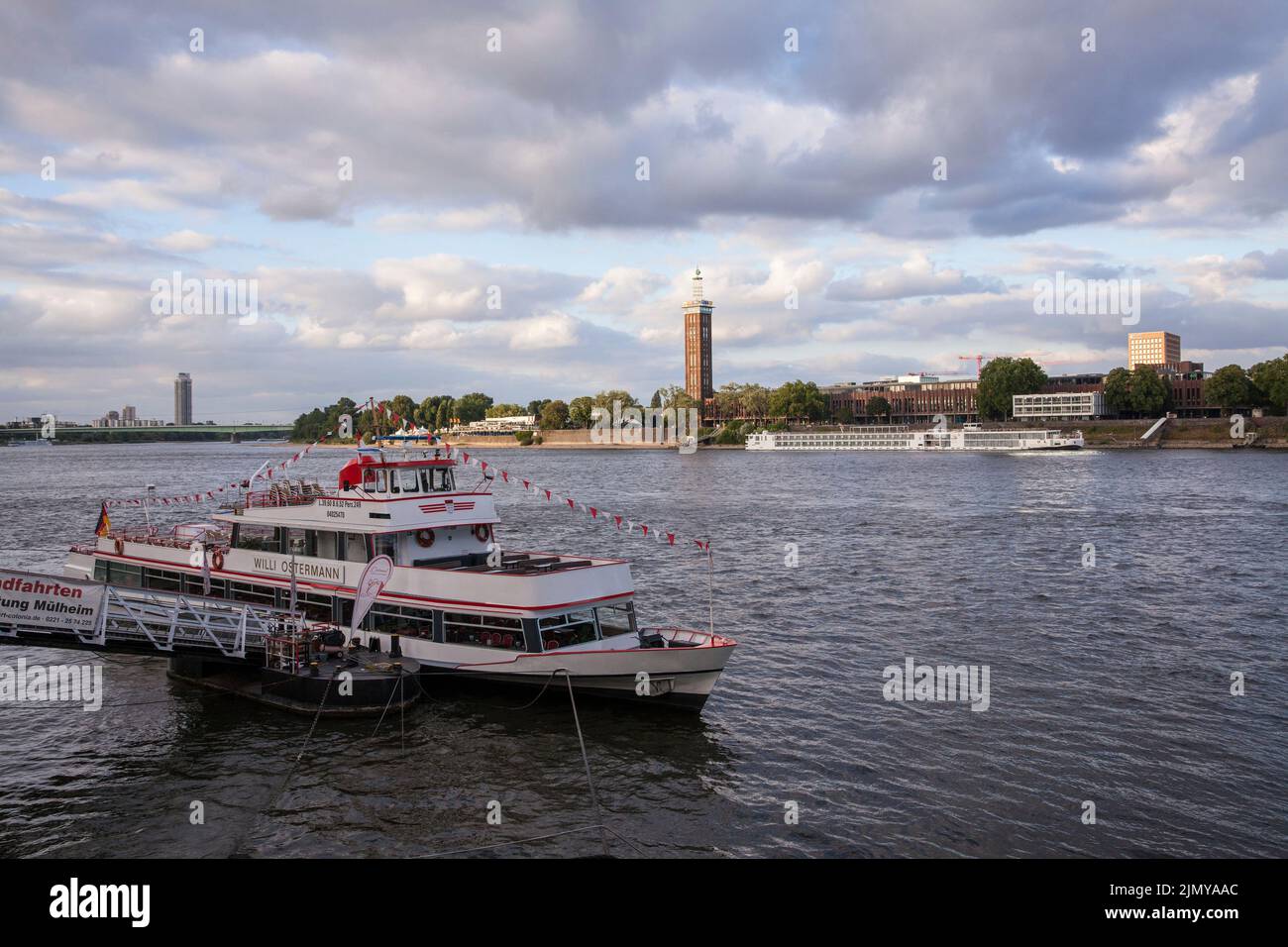 Vue sur le Rhin jusqu'au quartier Deutz avec l'ancienne tour du centre d'exposition, bateau d'excursion à une jetée, Cologne, Allemagne. Blick über Banque D'Images