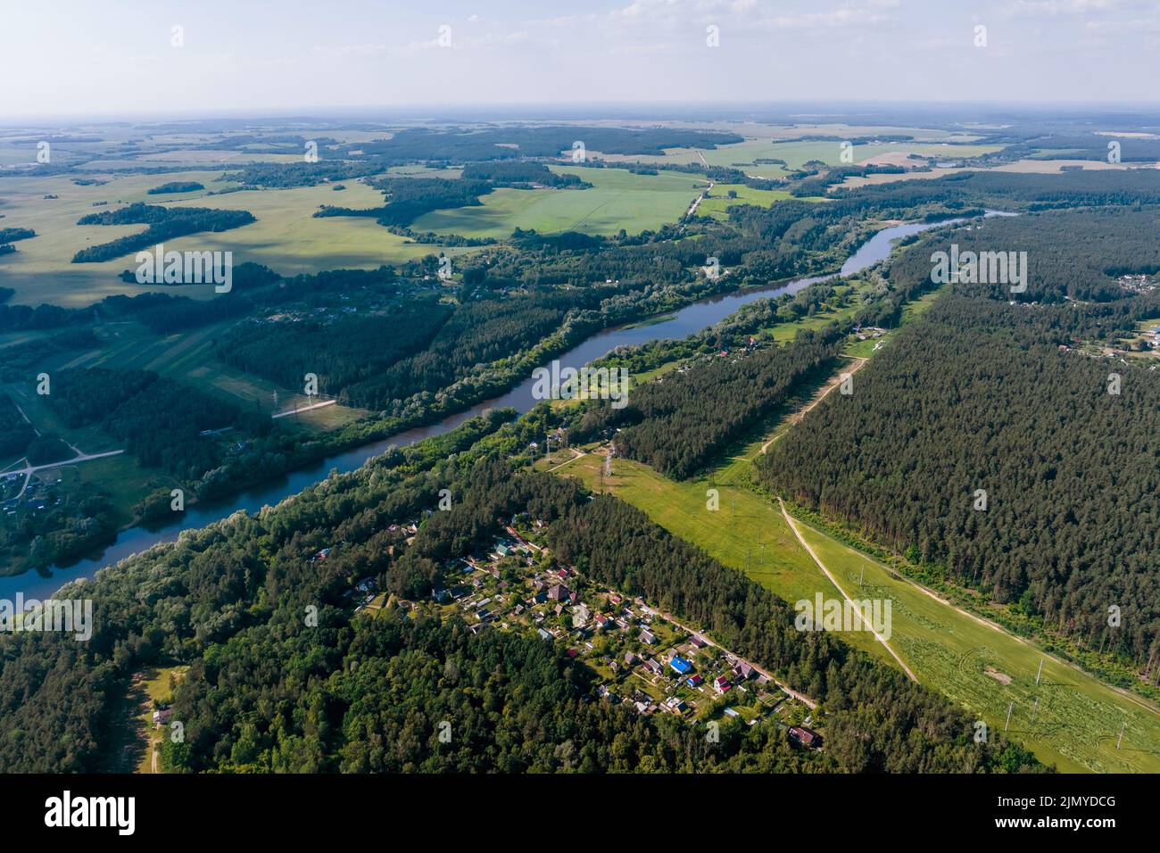 vue panoramique aérienne du village vert avec des maisons en forêt près d'une rivière large Banque D'Images