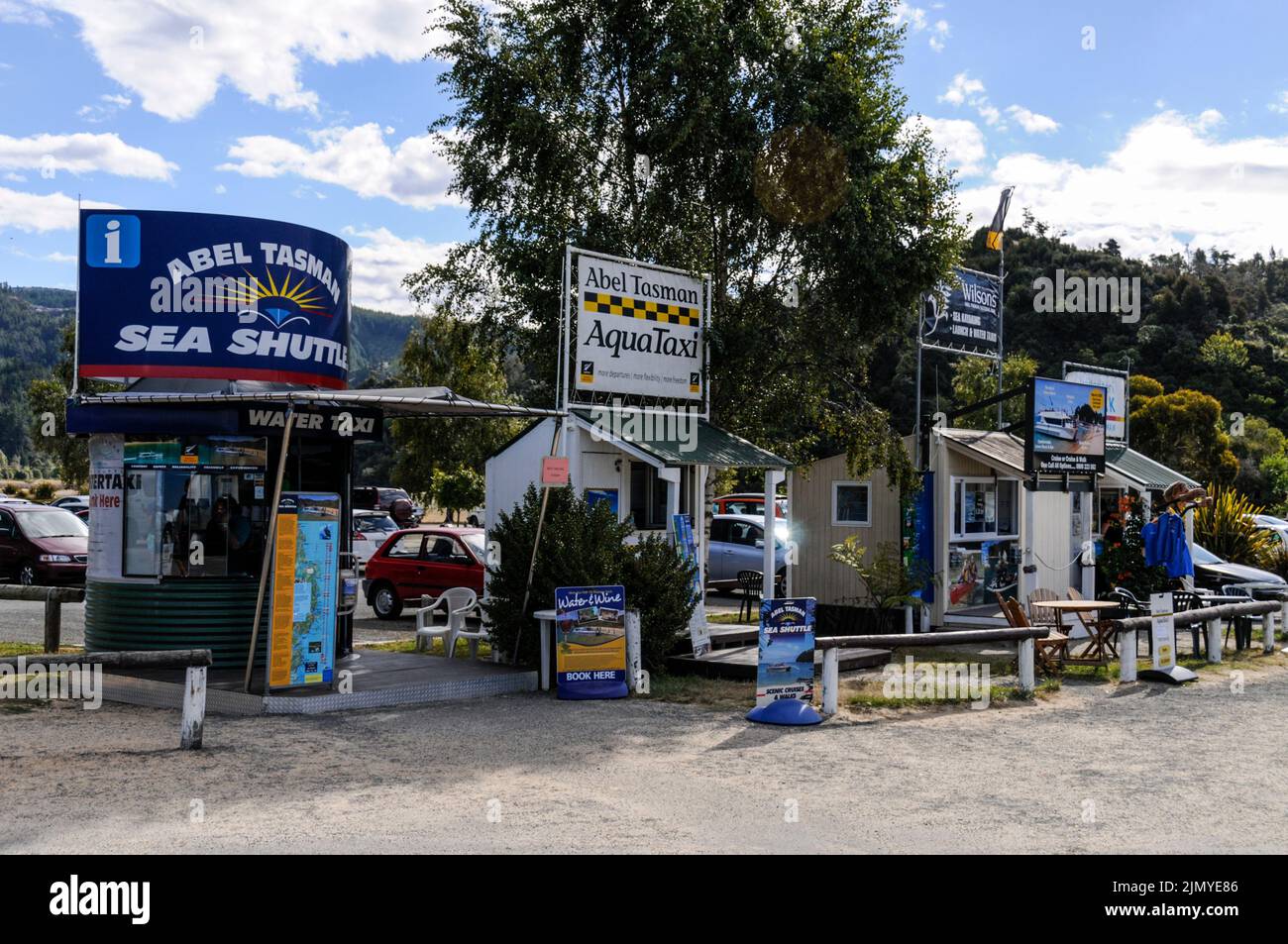Une rangée de kiosques de réservation de bateaux-taxis sur la plage de Kaitertiteri, en bordure du parc national d'Able Tasman, sur l'île du Sud, en Nouvelle-Zélande Banque D'Images