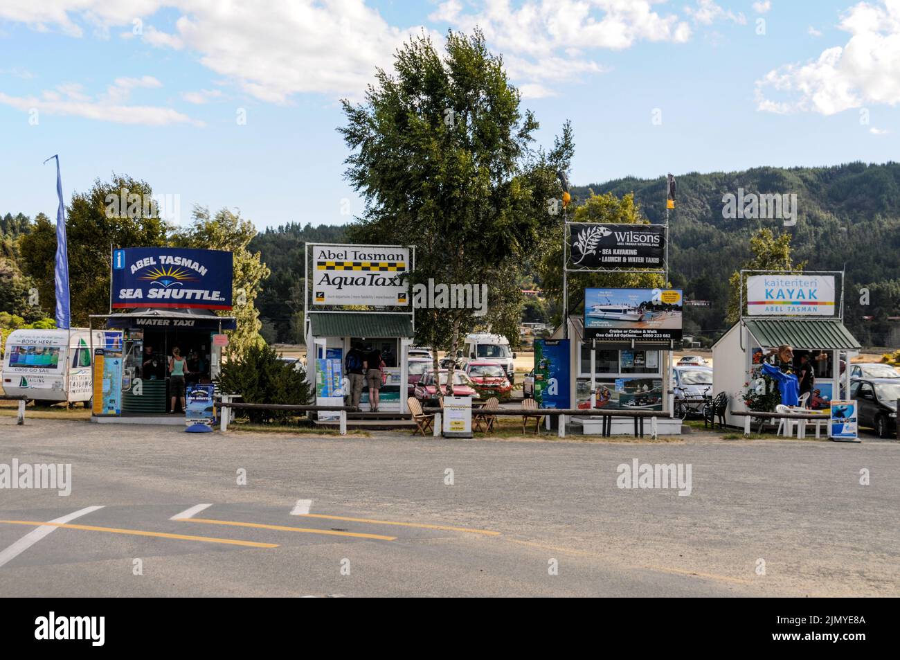 Une rangée de kiosques de réservation de bateaux-taxis sur la plage de Kaitertiteri, en bordure du parc national d'Able Tasman, sur l'île du Sud, en Nouvelle-Zélande Banque D'Images