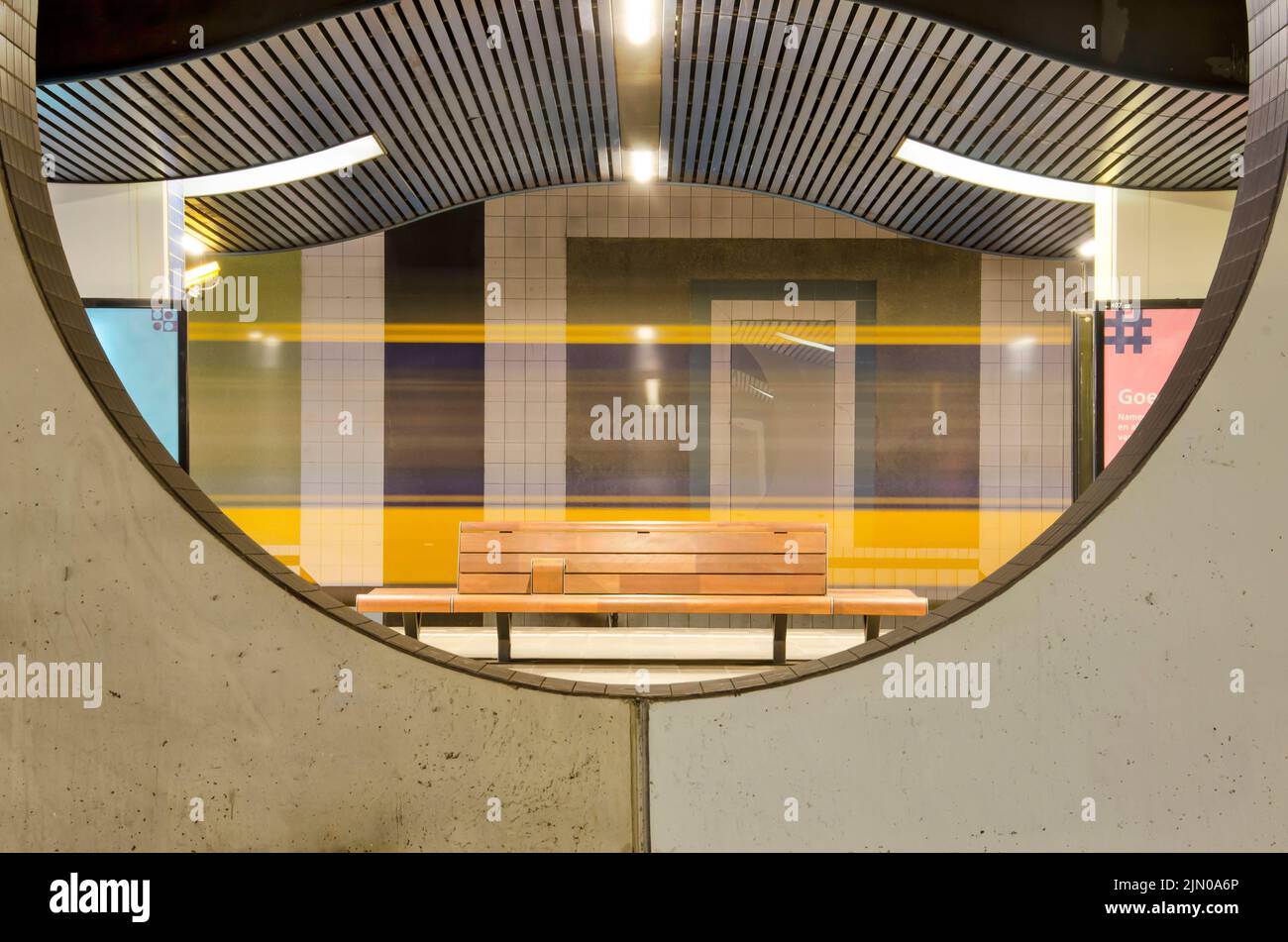 Rotterdam, pays-Bas, 10 juin 2022: Train passant par la station de métro Blaak, vu par une ouverture circulaire dans un mur en béton Banque D'Images
