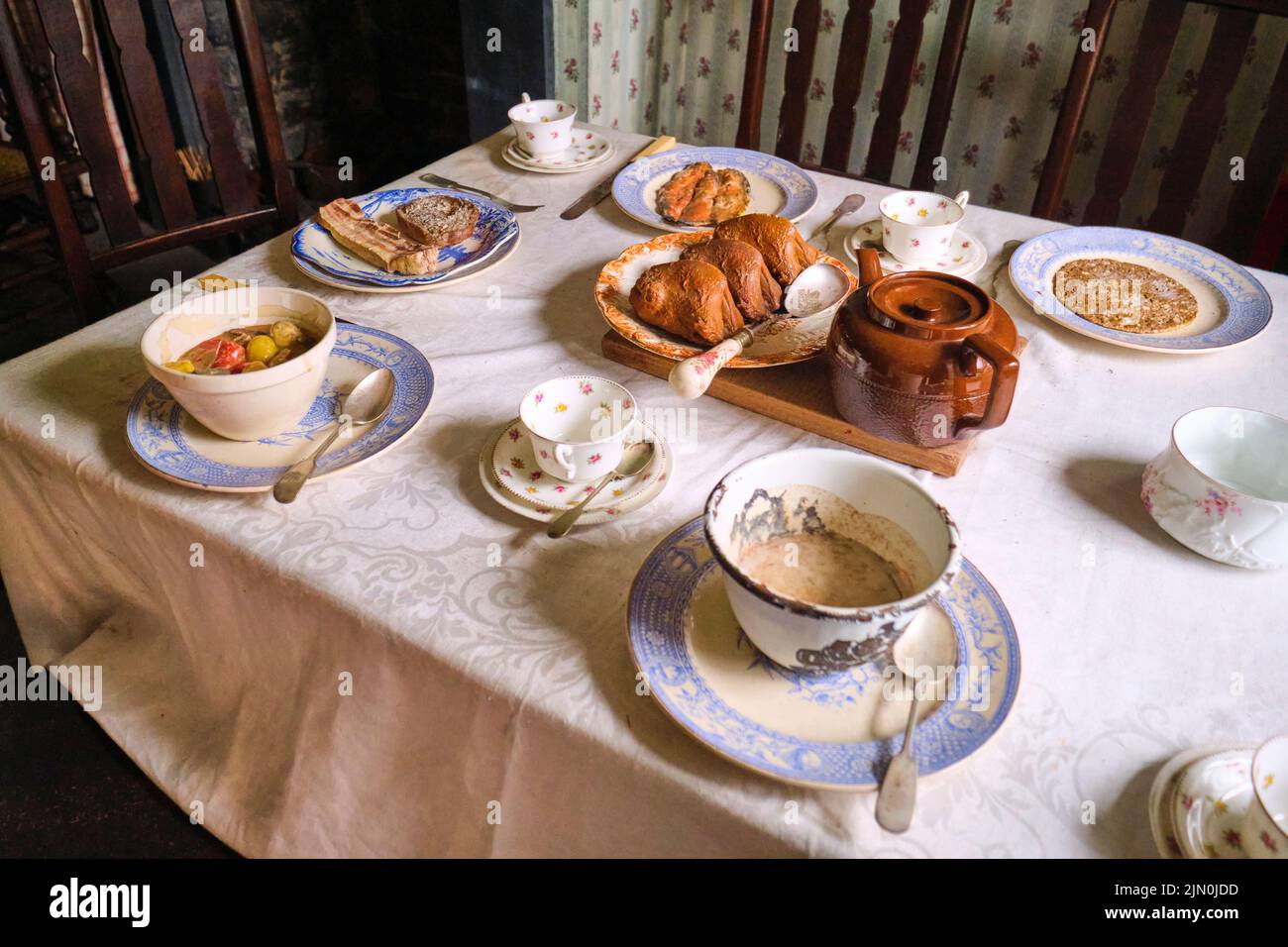 Un repas typique, du thé et de la fausse nourriture. Ragoût, poules corniches, bacon, pain, poisson. Dans une récréation d'une maison de travailleur typique, maison de 1927 à Bla Banque D'Images