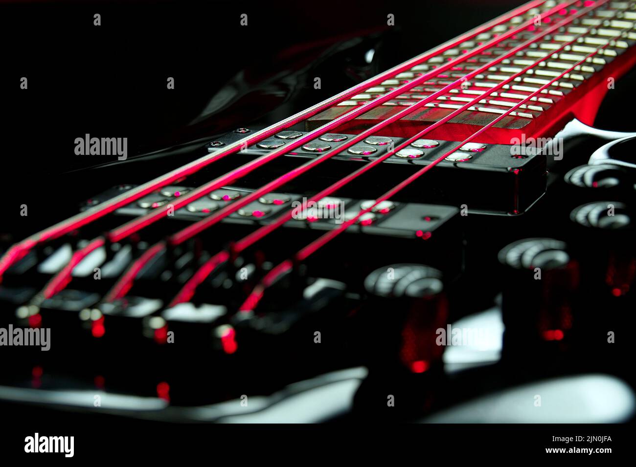 Guitare basse en lumière blanche et rouge. Banque D'Images