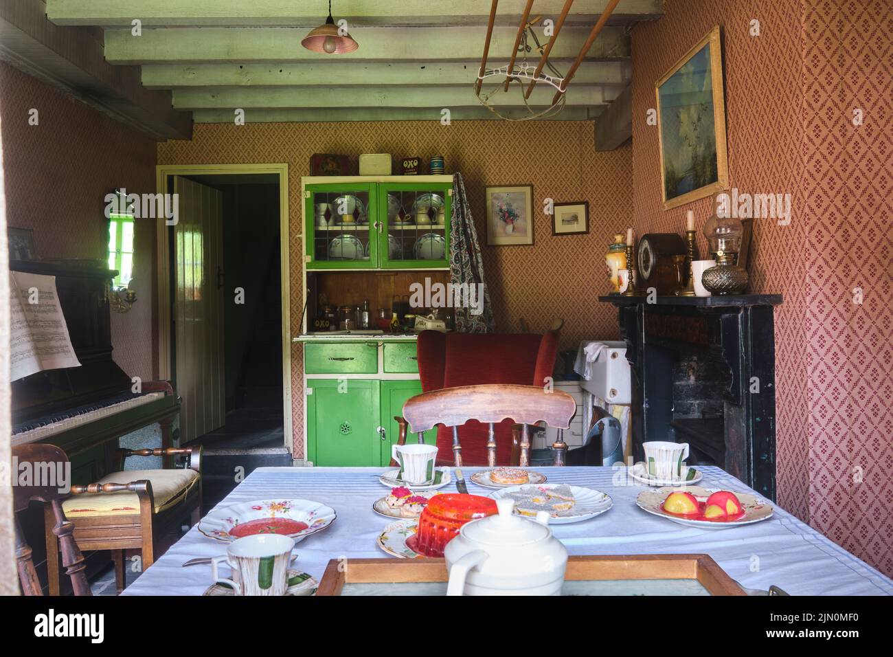 Le salon, salle à manger avec table et armoire à vaisselle. Dans une récréation d'une maison de travail typique, maison de 1955 à Blaenavon Ironworks en BL Banque D'Images