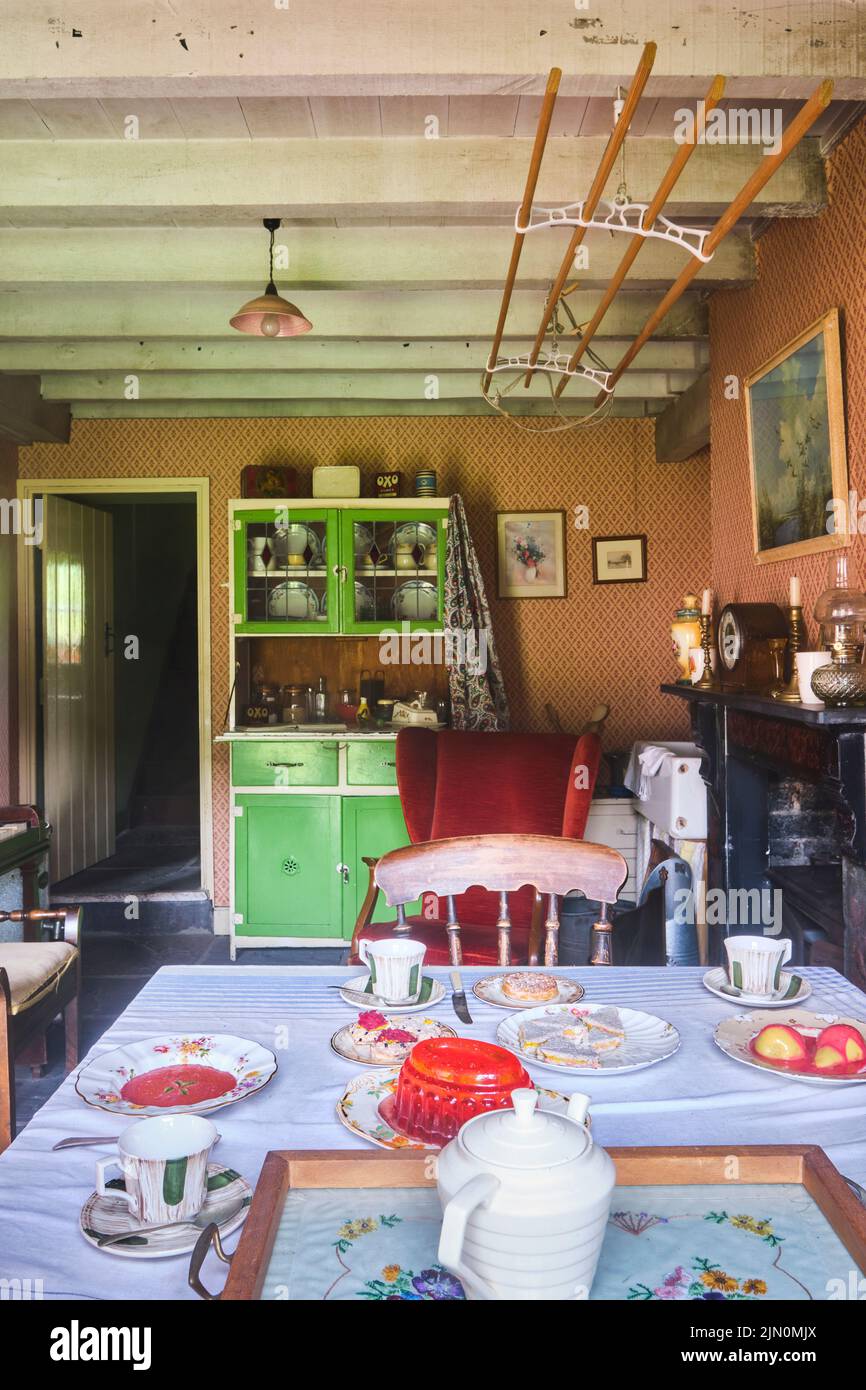 Le salon, salle à manger avec table et armoire à vaisselle. Dans une récréation d'une maison de travail typique, maison de 1955 à Blaenavon Ironworks en BL Banque D'Images