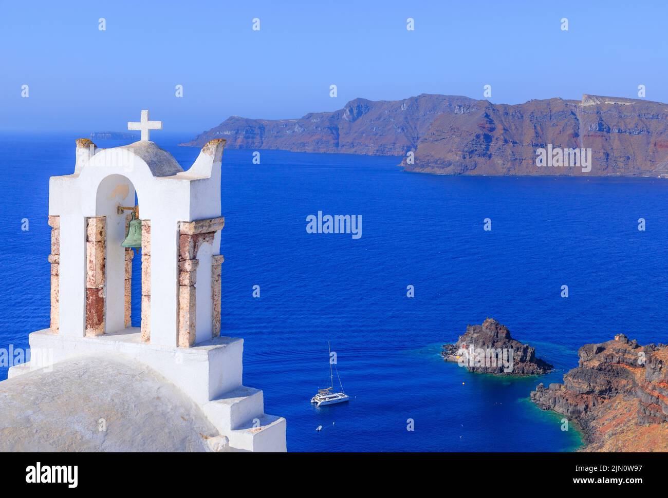 Île de Santorini : clocher typique d'Oia avec la caldeira en arrière-plan. Banque D'Images