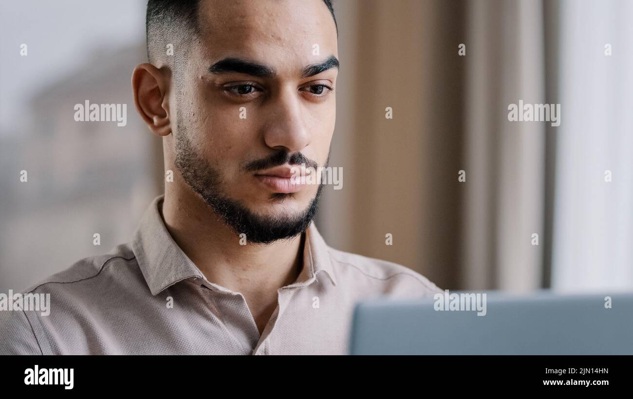 Gros plan portrait masculin calme arabe homme d'affaires gars hispanique homme indépendant web designer dactylographiant e-mail sur ordinateur portable à domicile usage personnel Banque D'Images