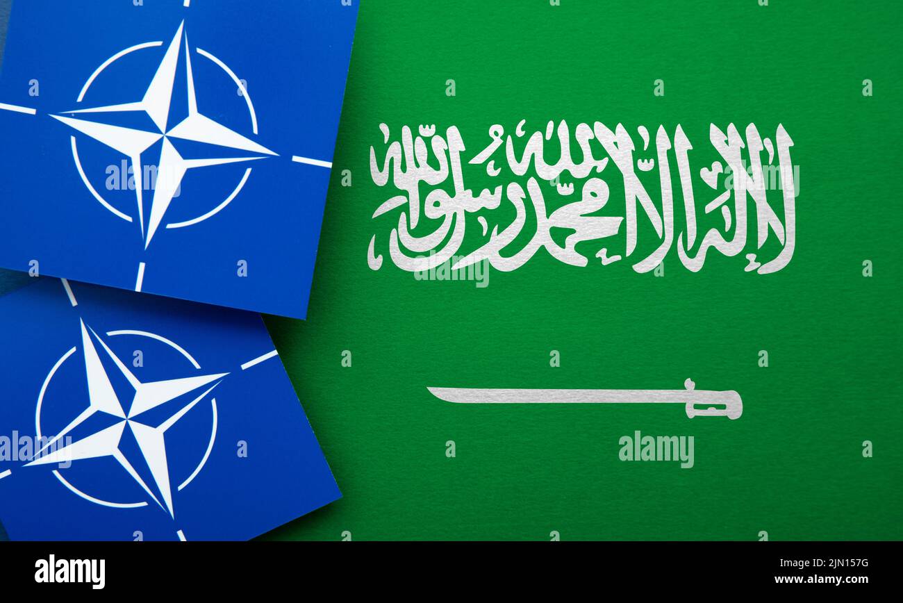 LONDRES, Royaume-Uni - août 2022 : logo de l'alliance militaire de l'Organisation du Traité de l'Atlantique Nord de l'OTAN sur un drapeau de l'arabie saoudite Banque D'Images