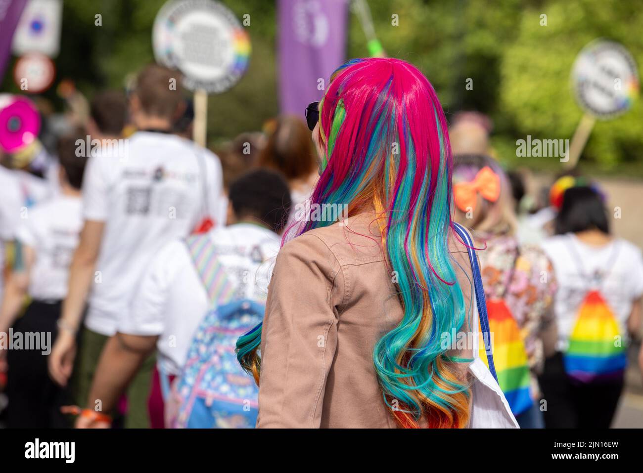 Une femme d'âge moyen aux cheveux roses et arc-en-ciel marche à la London Pride 2022 Banque D'Images
