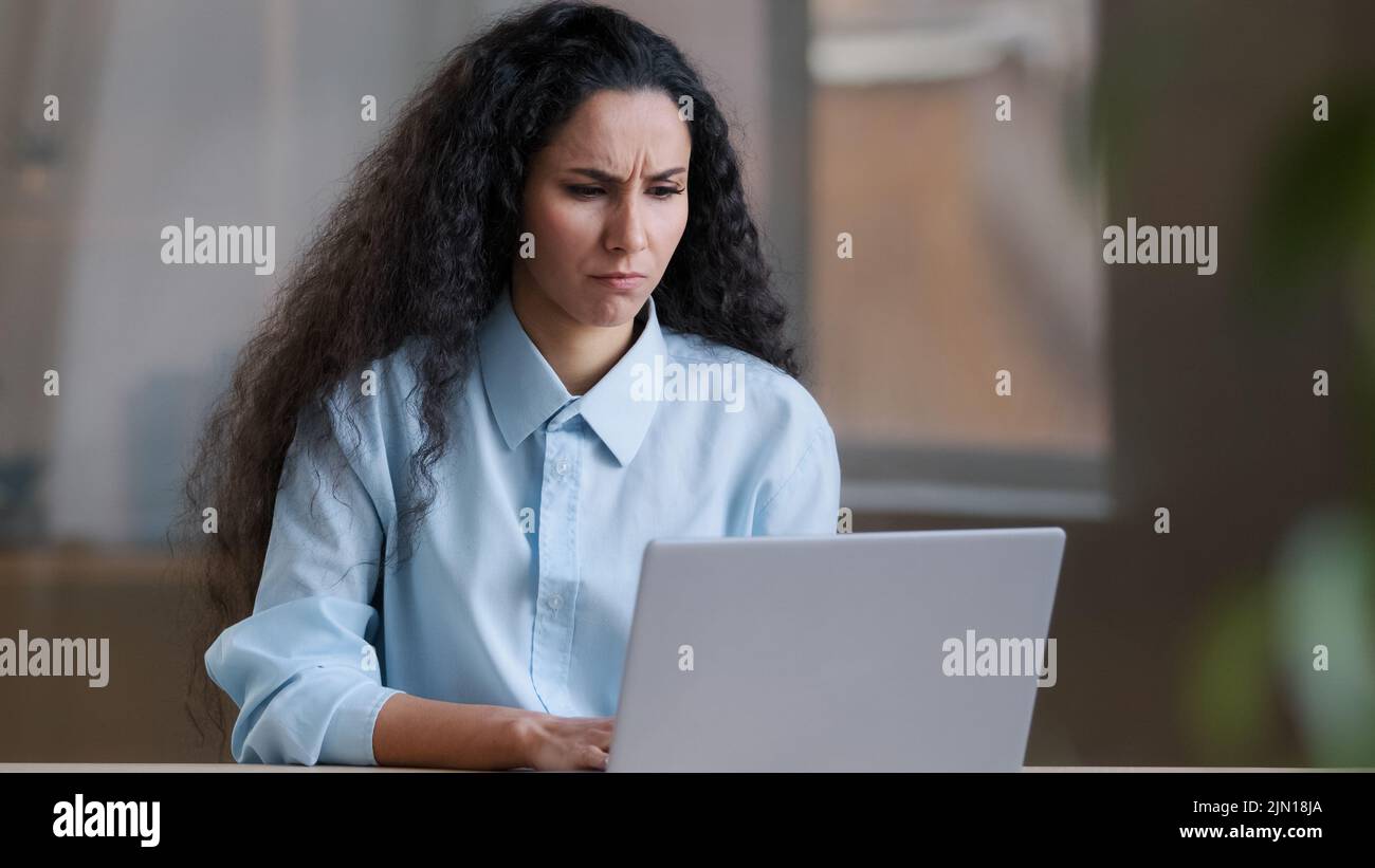 Contrarié femme d'affaires arabe inquiet travailleur exécutif fille hispanique freelancer travail en ligne sur ordinateur déçu par le problème financier inconnu Banque D'Images