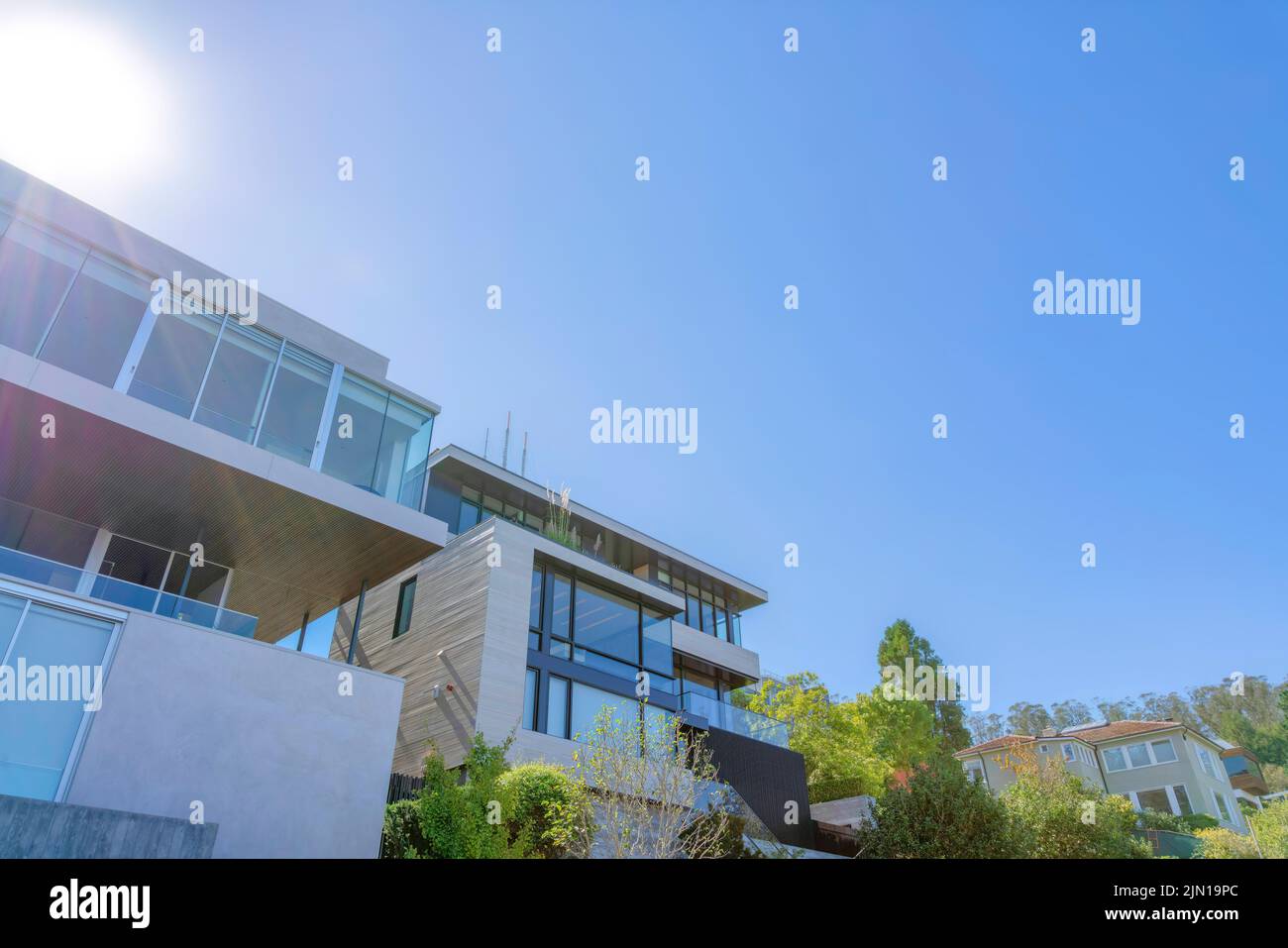 Vue à angle bas des maisons modernes avec du verre du sol au plafond contre le soleil à San Francisco, CA. Grandes maisons avec balustrades en verre sur ses balcons. Banque D'Images