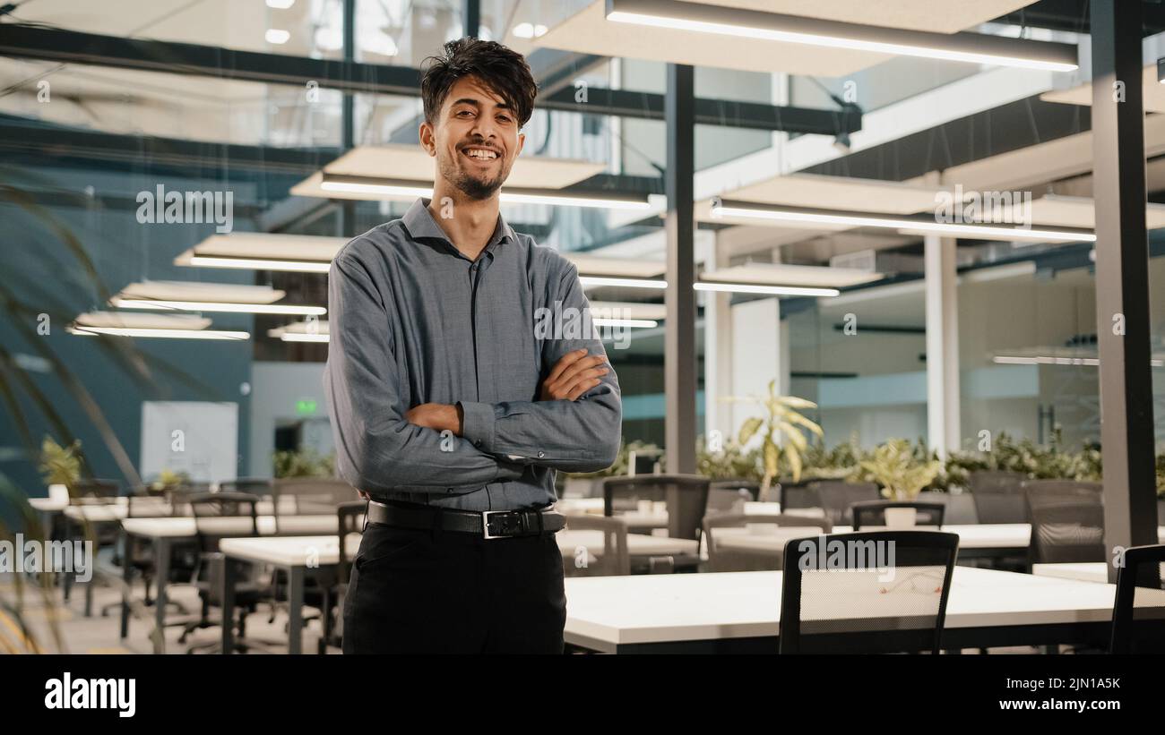Confiant sourire indien jeune homme homme homme homme homme d'affaires fondateur investisseur vendeur gestionnaire faire des armes croisées stand dans le bureau beau adulte homme analyste Banque D'Images