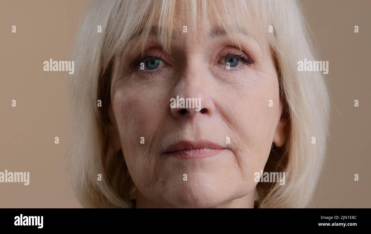 Gros plan portrait de femme en studio tête d'intérieur visage ridé calme sérieux granny mature 60s femme blonde d'âge moyen dame âgée grand-mère âgée Banque D'Images