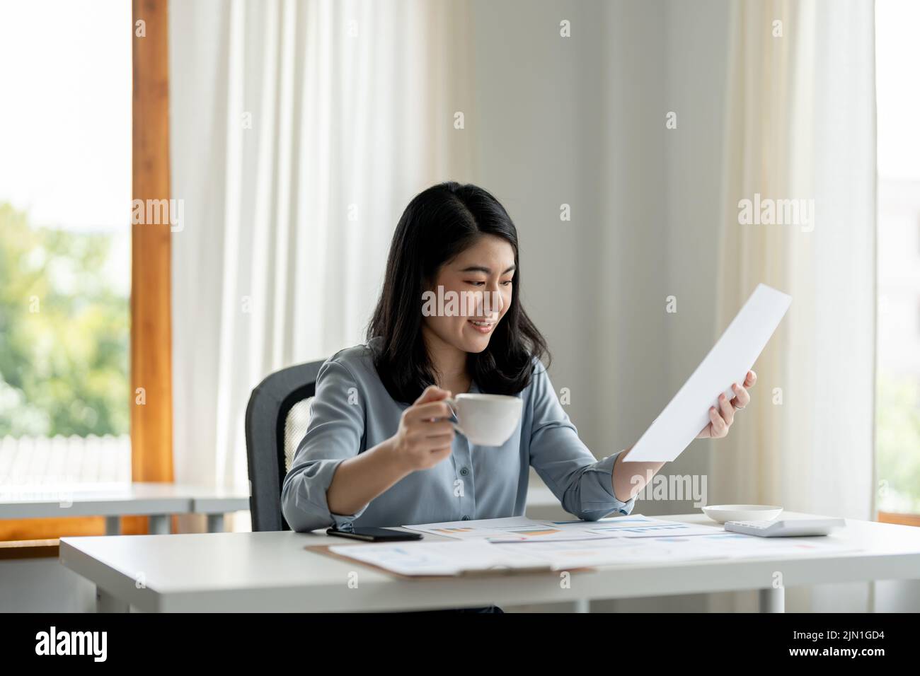 femme d'affaires vérifie les finances et les revenus de l'entreprise et le budget avec graphique sur le bureau. Banque D'Images