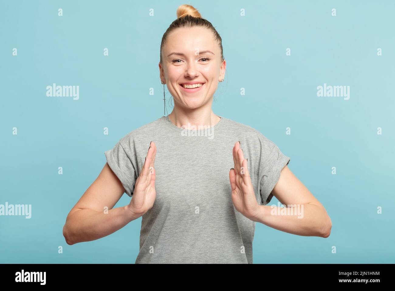 femme souriante tient un gros objet virtuel main vide Banque D'Images