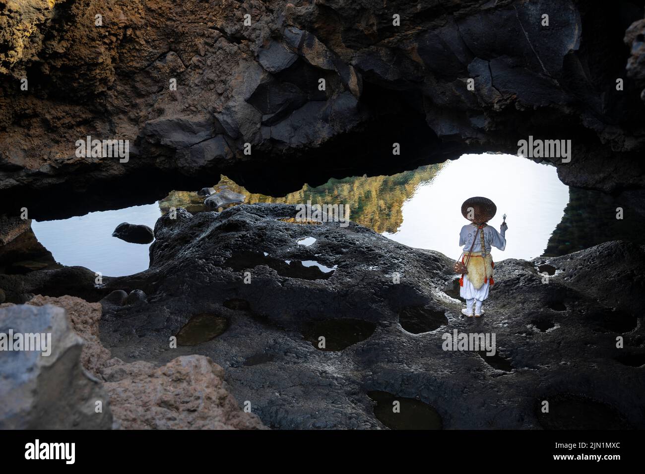 Le moine Shugendo est assis dans une grotte et médite tout en regardant la mer ouverte Banque D'Images