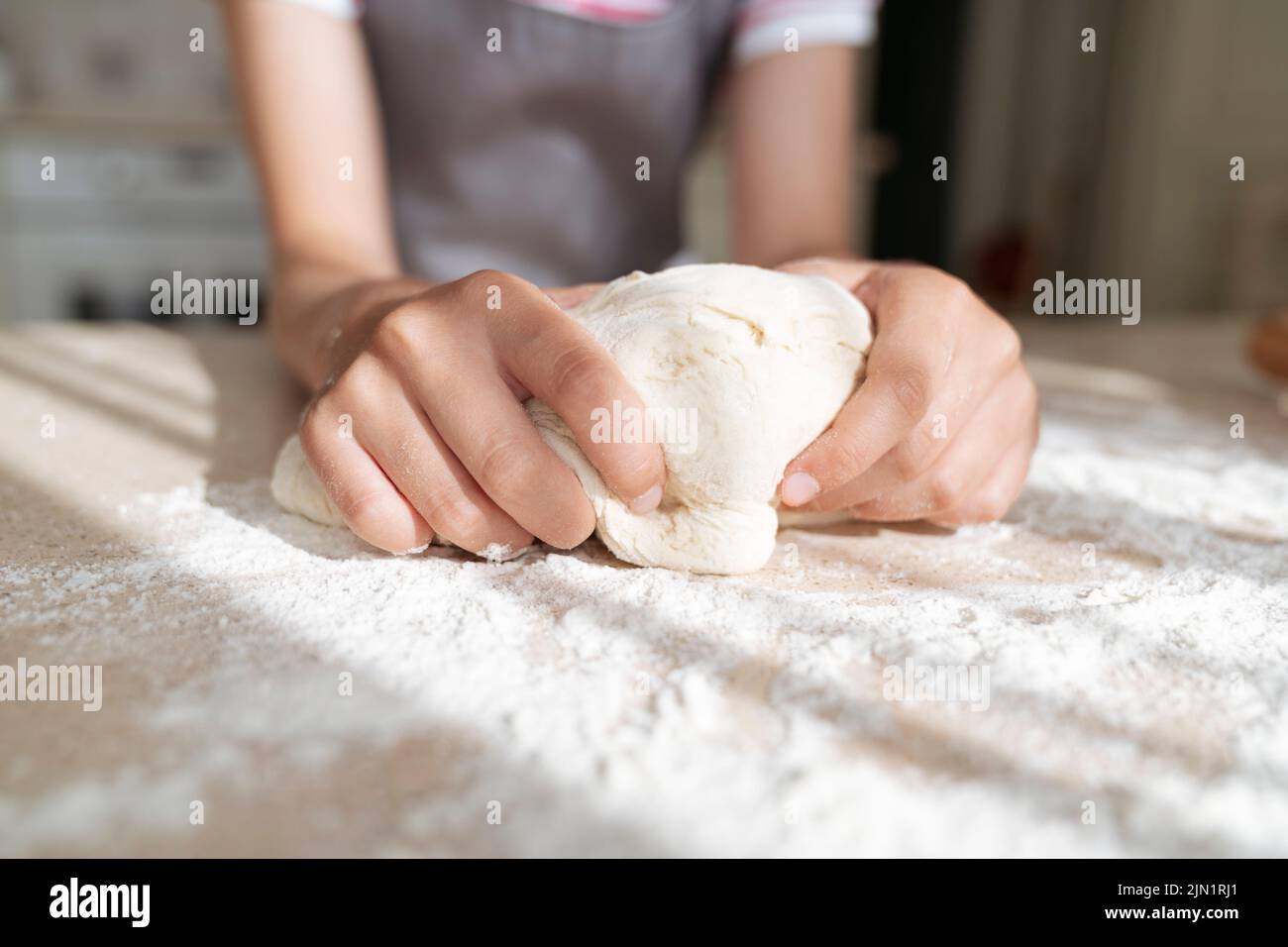 Les mains de fille avec la pâte et la farine gros plan. Banque D'Images