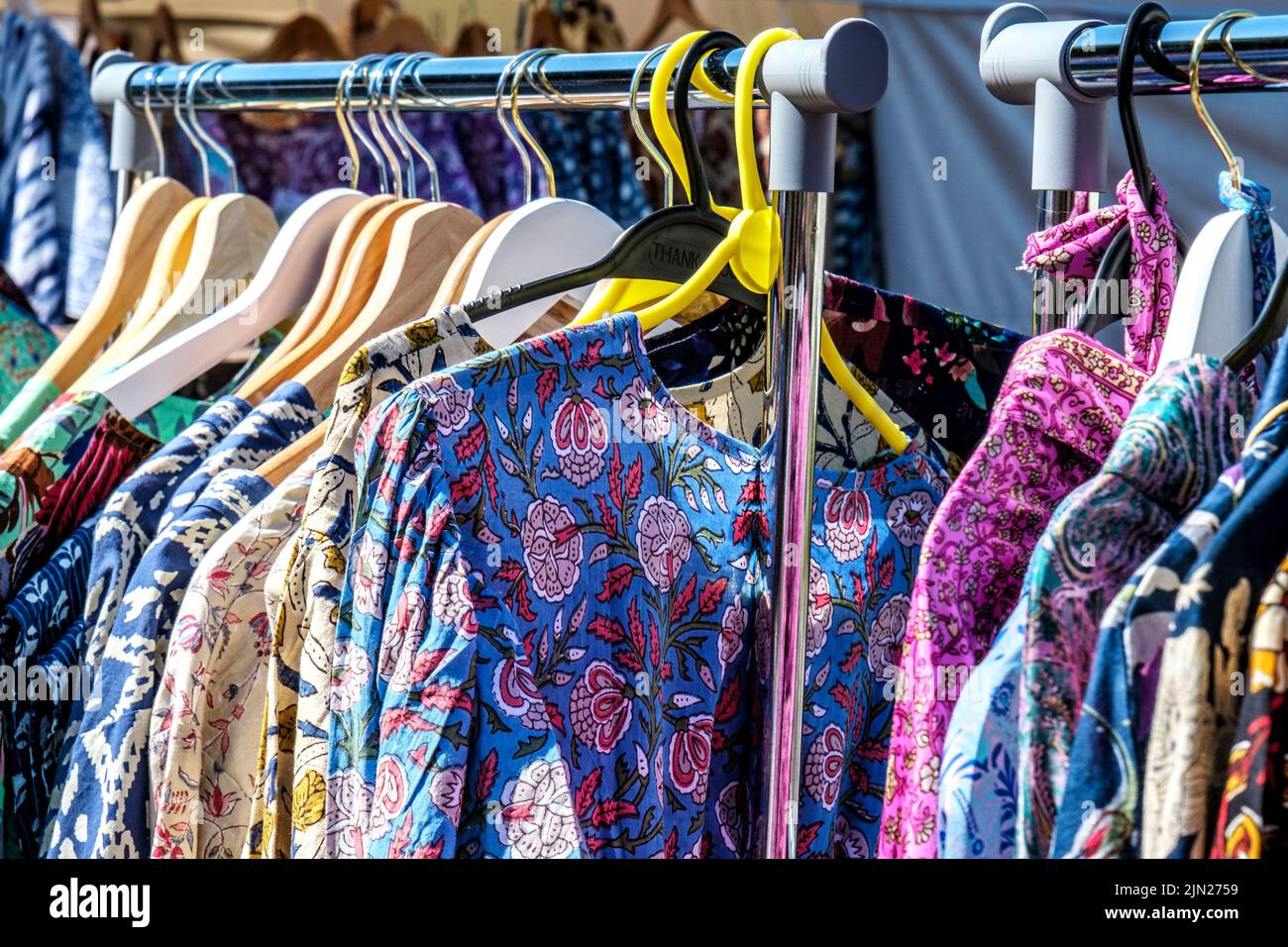 Dorking, Surrey Hills, Londres, Royaume-Uni, 07 juillet 2022, vêtements colorés d'origine indienne suspendus sur des rails dans un marché ouvert de commerçants Banque D'Images
