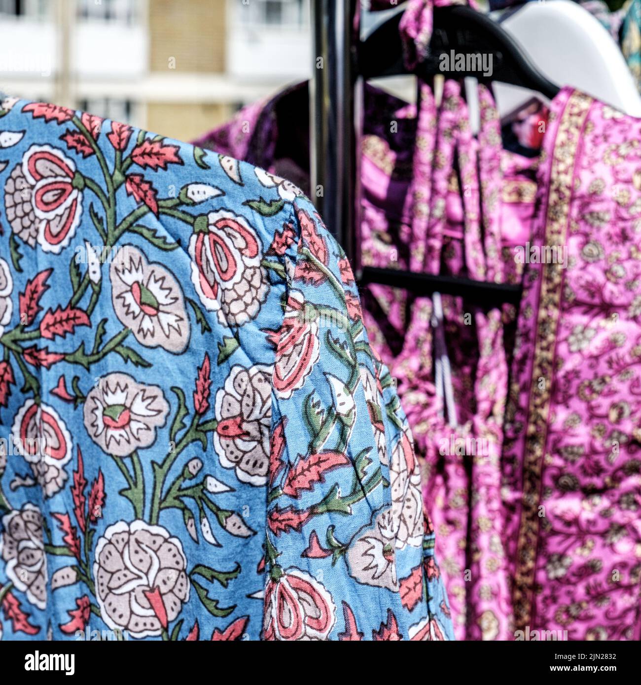 Dorking, Surrey Hills, Londres, Royaume-Uni, 07 juillet 2022, robes pour femmes colorées et lumineuses suspendues dans un marché extérieur tout en l'absence de personne Banque D'Images