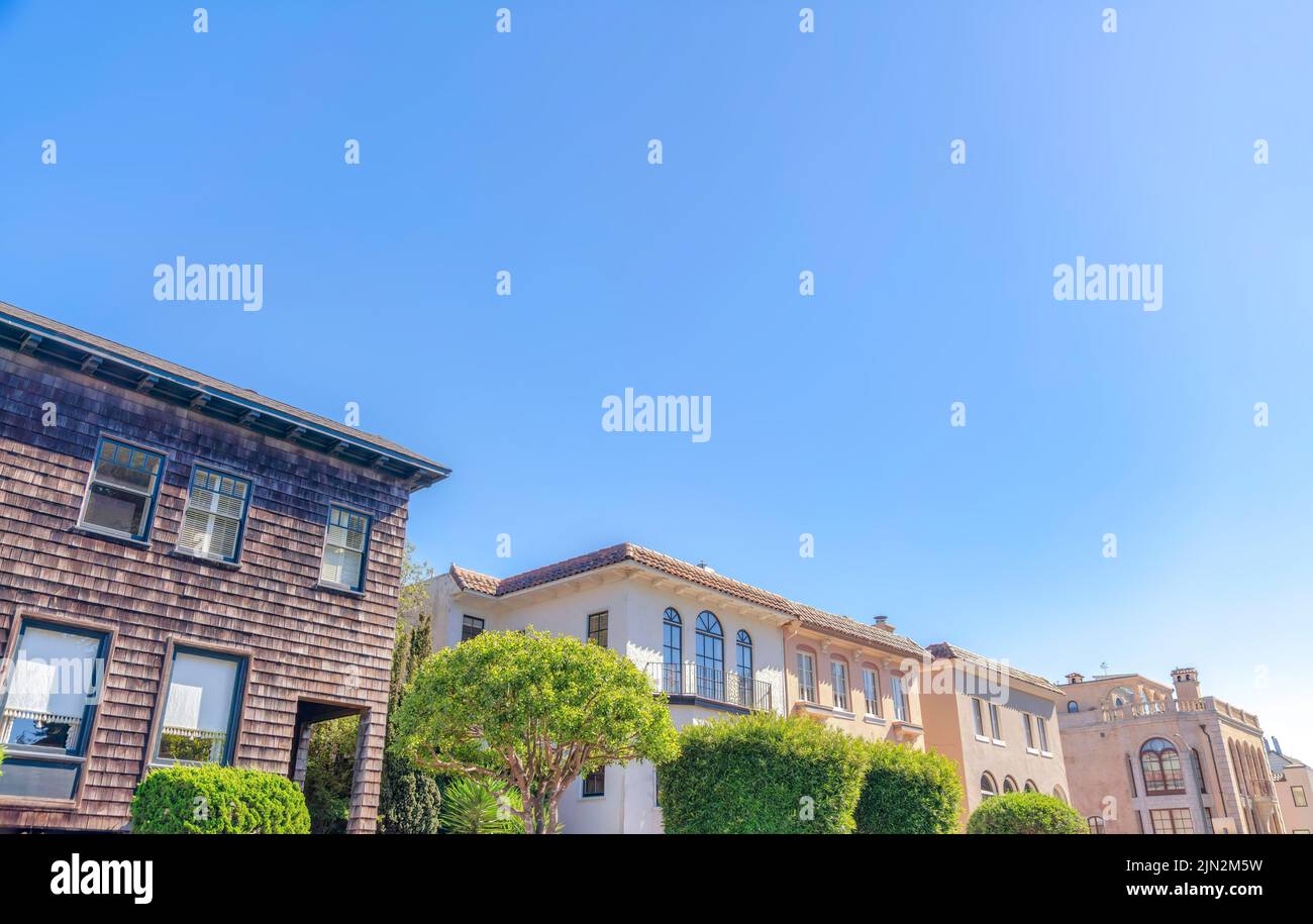 Rangée de maisons méditerranéennes et victoriennes à San Francisco, Californie. Il y a une maison sur la droite avec parement de bardeaux en bois foncé avec le medi Banque D'Images