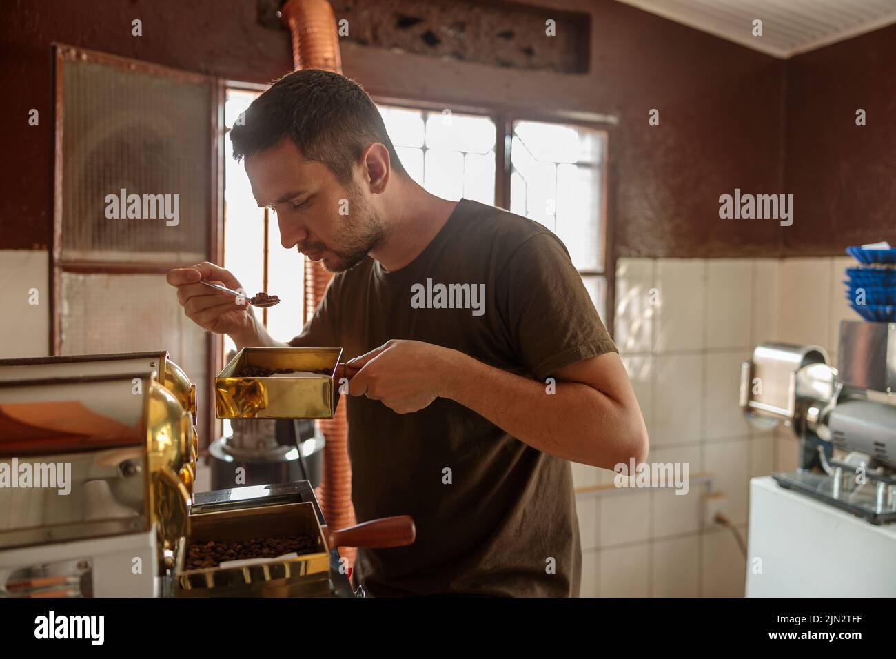Q la niveleuse tient sa cuillère avec le café pendant la dégustation Banque D'Images