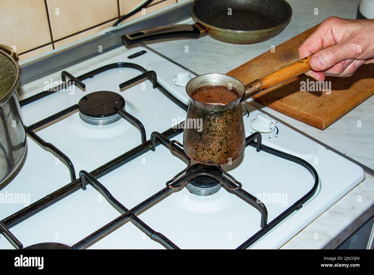 Le café moulu est infusé dans une cezve de cuivre sur un poêle à gaz. Banque D'Images