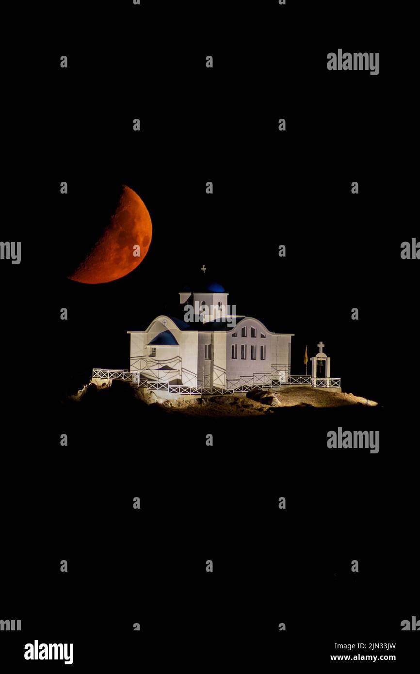 L'église d'Agios Nikolaos dans le port de Myrina sur l'île de Limnos, avec la lune rouge dans le cadre Banque D'Images