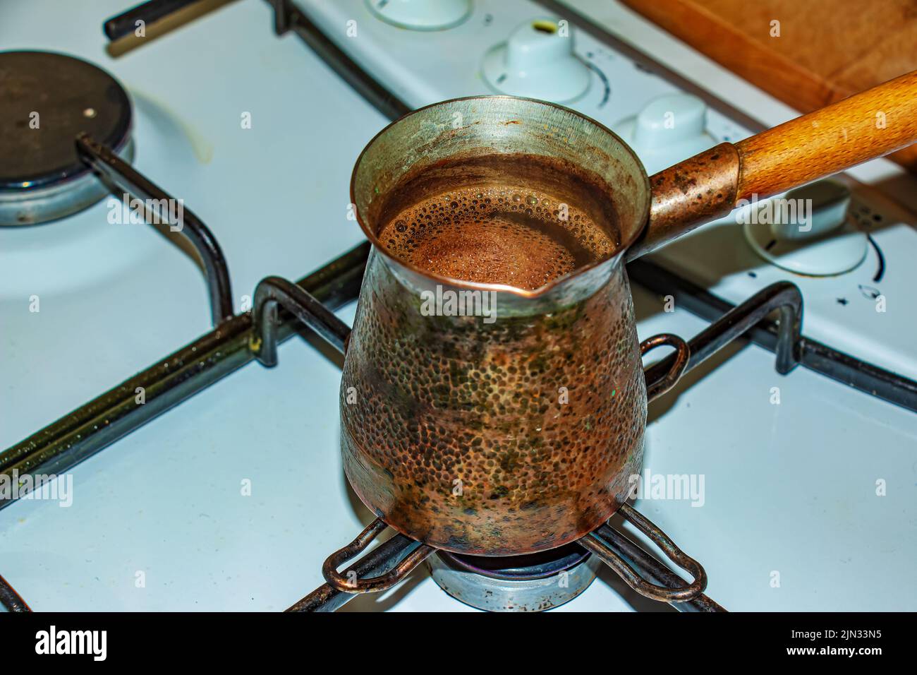 Le café moulu est infusé dans une cezve de cuivre sur un poêle à gaz. Banque D'Images