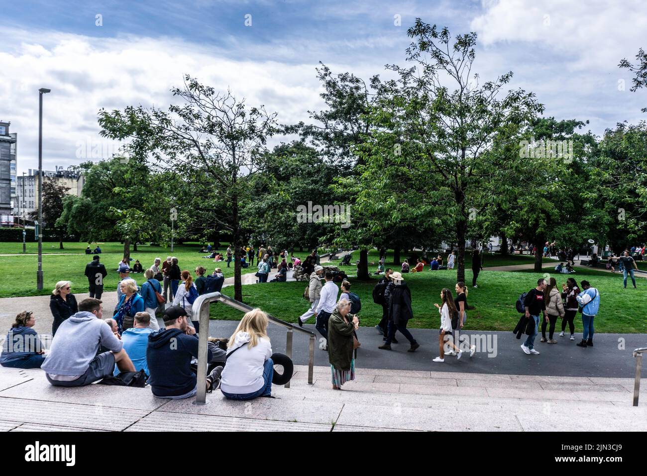 La foule se trouve sur Eyre Square à Galway, en Irlande, un samedi après-midi, profitant du soleil d'août. Banque D'Images