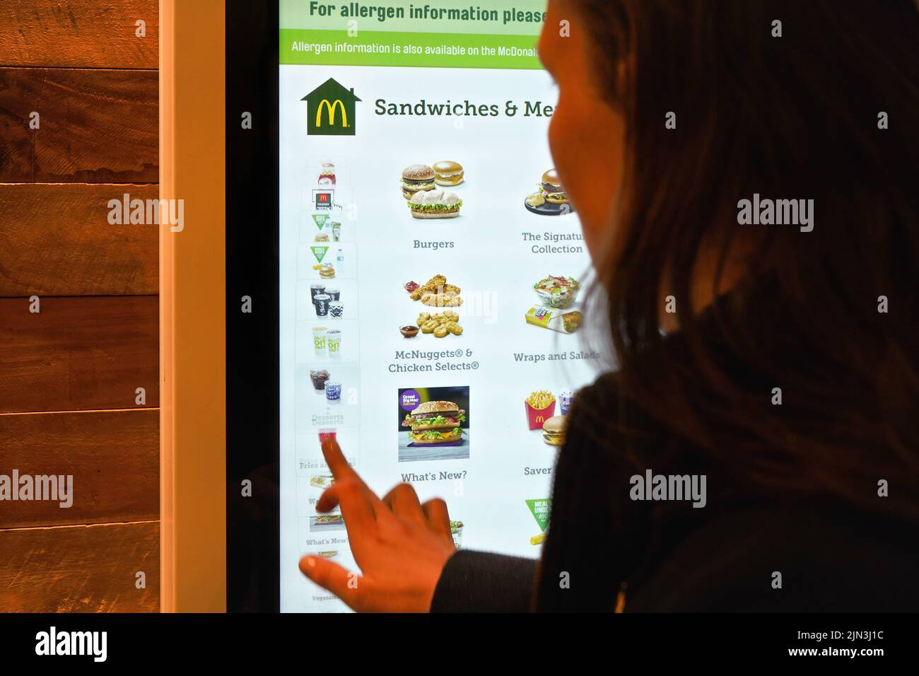 Londres, Royaume-Uni - 01 février 2019: Femme commandant de la nourriture sur grand écran tactile à l'une des branches de McDonalds, gros plan détail de derrière Banque D'Images