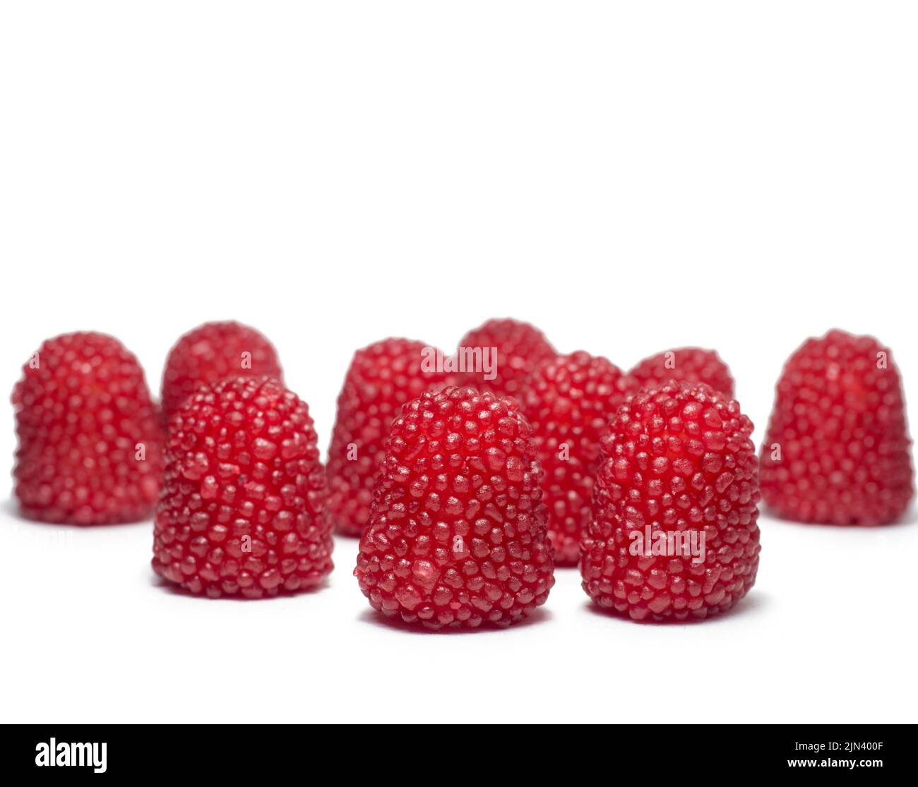 bonbons à mâcher rouges sous forme de baies. Bonbons sous forme de framboises sur fond blanc. Isolat de marmelade. Bonbons pour les enfants. Aliments sucrés Banque D'Images