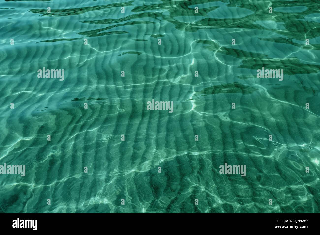 L'eau cristalline est ondulée et les reflets ensoleillés sur la surface de la mer. Arrière-plan naturel Banque D'Images