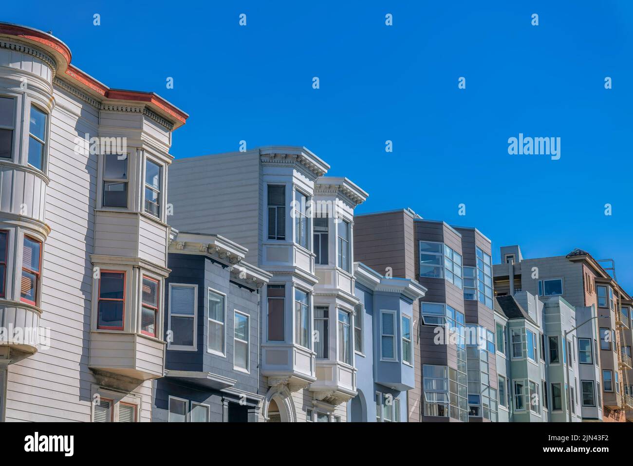 Vue latérale de chemisiers avec baies vitrées contre le ciel à San Francisco, Californie. Façade de maisons avec différents types d'extérieur et peint WO Banque D'Images
