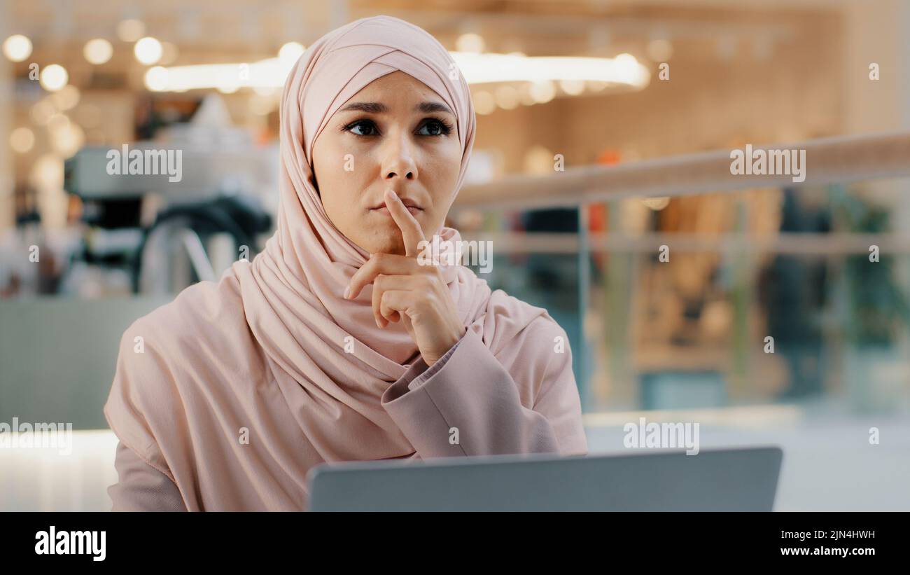 Pensive réfléchie inquiète jeune arabe femme écrivain travaillant sur ordinateur portable pense nouvelle idée démarrage développe plan écrit roman trouve la solution au problème Banque D'Images