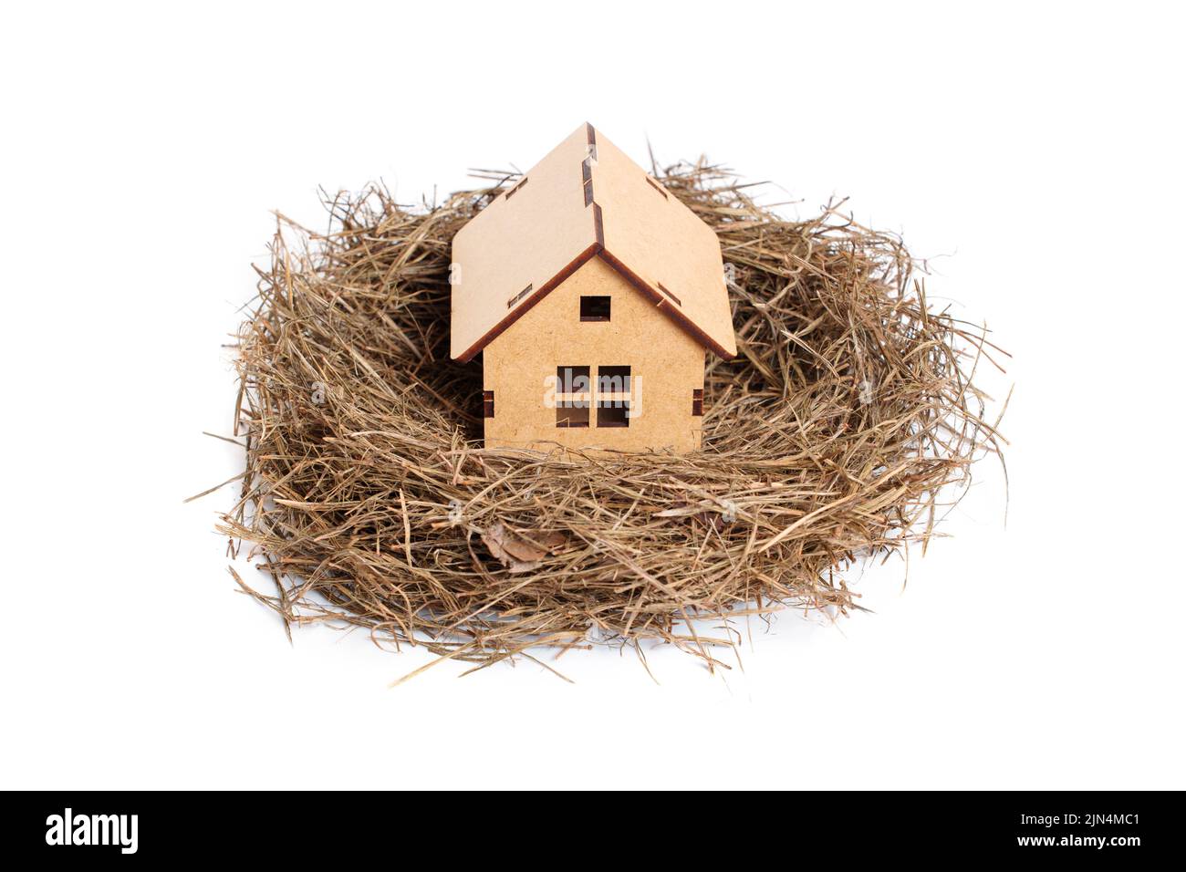 Nid d'oiseau avec une petite maison en bois isolée sur blanc. Concept hypothécaire. Banque D'Images
