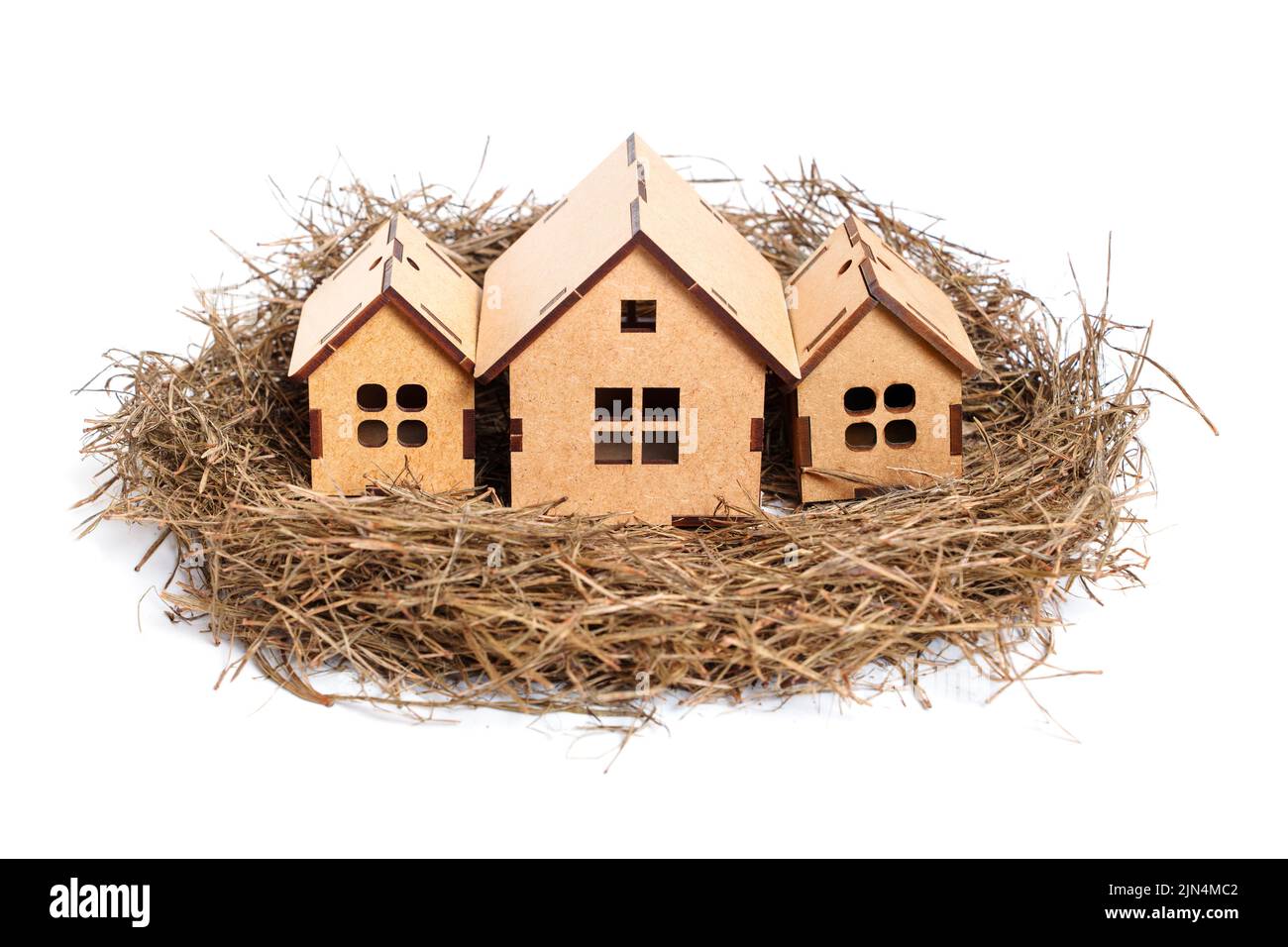 Nid d'oiseau avec trois maisons en bois auto-assemblées isolées sur fond neutre. Concept de logement résidentiel sûr. Banque D'Images