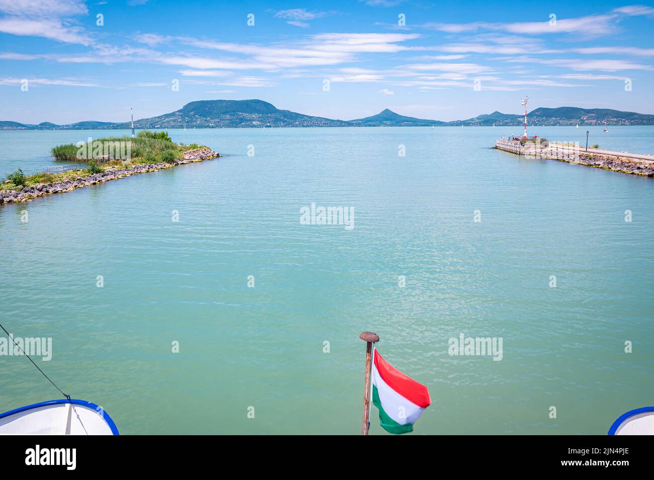Un bateau quitte le port de Fonyód au lac Balaton en Hongrie. Drapeau hongrois au premier plan. Banque D'Images