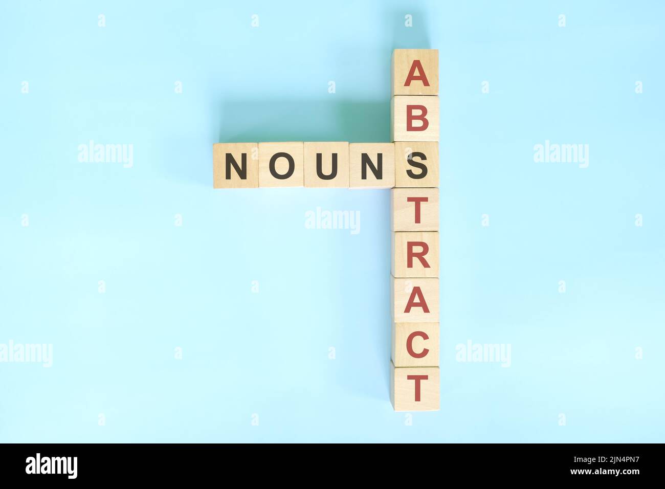 Résumé nouns concept dans la grammaire anglaise noun éducation. Jeu de mots croisés en bois posé sur fond bleu. Banque D'Images