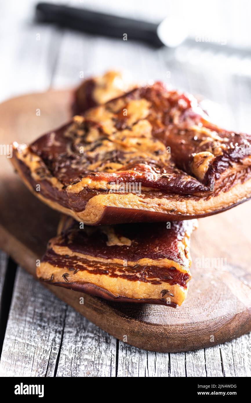 Bacon fumé entier sur une planche à découper. Banque D'Images