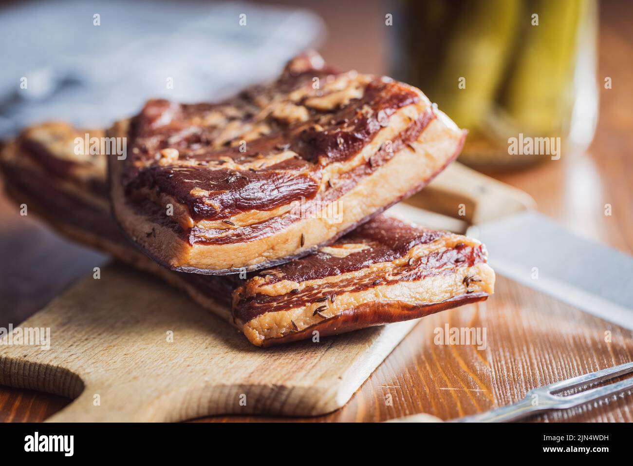 Bacon fumé entier sur une planche à découper. Banque D'Images