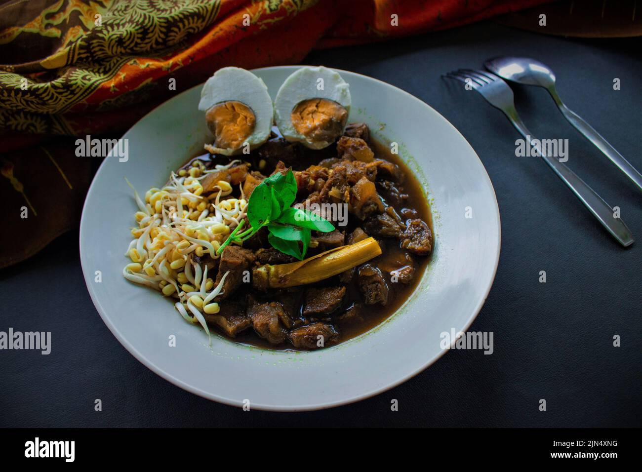 Rawon ou Nasi Rawon/Rawon Rice est une soupe noire traditionnelle de bœuf indonésien servie avec des pousses, des œufs salés et de l'assaisonnement au kluwek. De l'est de Java. Isolé Banque D'Images