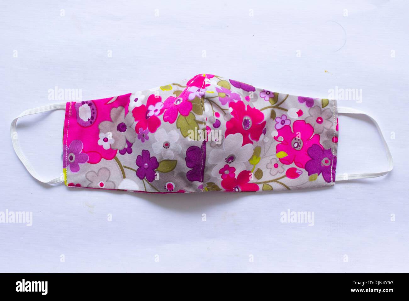 masque en tissu ou masque en tissu avec motif fleuri en coton artisanal isolé sur fond blanc. Ce masque hygiénique pour couvrir la bouche et Banque D'Images