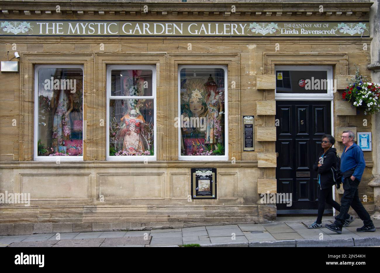 Un couple qui passe devant un magasin du nouvel âge sur Glastonbury's High-Street Banque D'Images