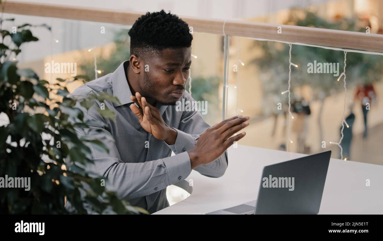 Un homme d'affaires sérieux frustré parlant par appel vidéo communique en ligne conférence par webcam sur ordinateur portable tenant des documents discutant de la mise en évidence des problèmes Banque D'Images