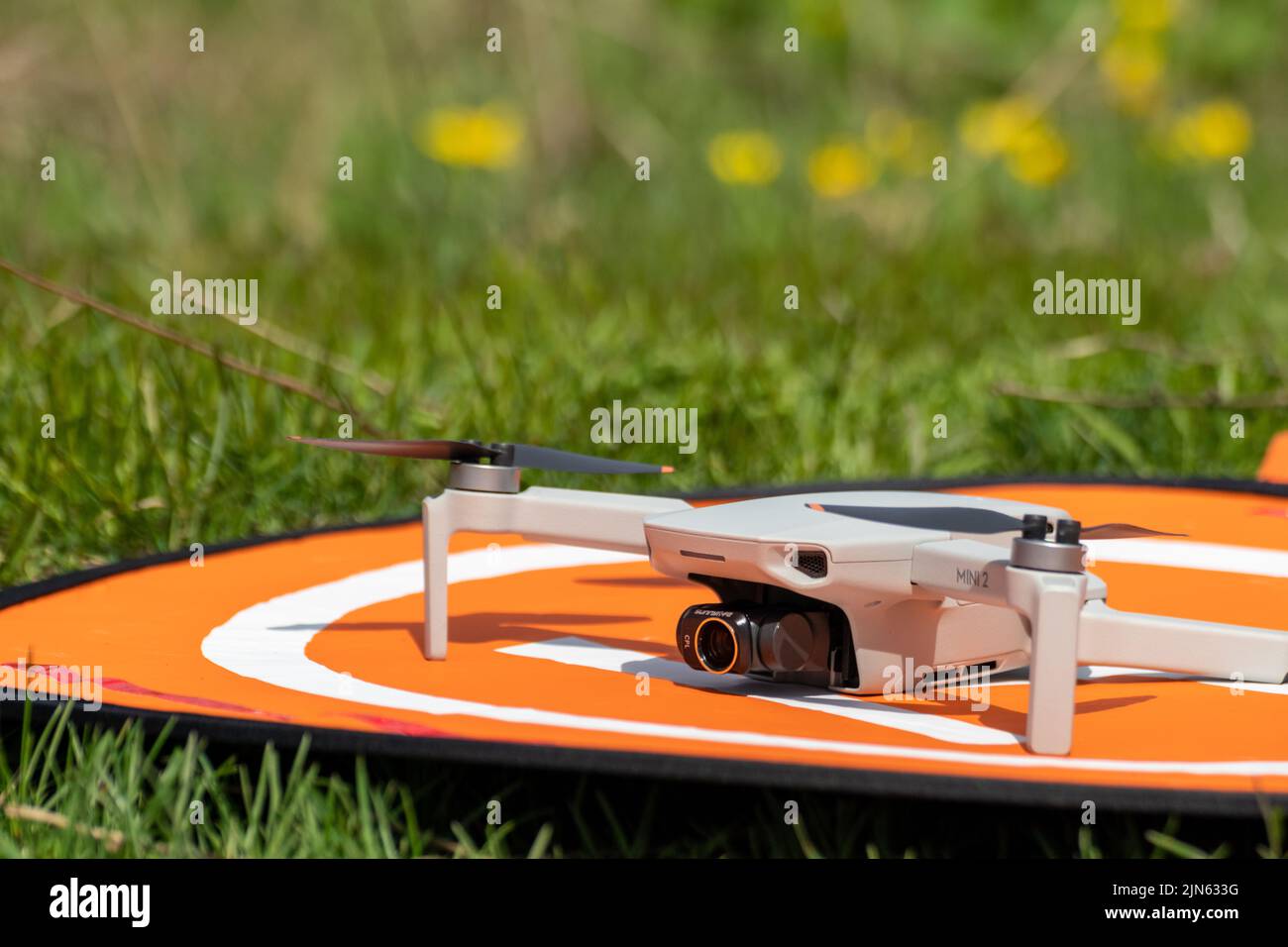 Kharkiv, Ukraine - 22 avril 2021: DJI Mavic Mini 2 drone avec cpl Lens filter gros plan sur la plate-forme d'atterrissage orange. Quadriptère sur le pavé de lancement pliable Banque D'Images