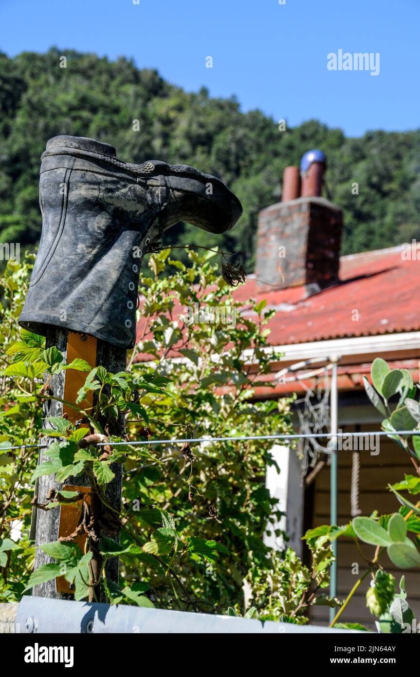Un casque d'accident de résident excentrique au-dessus d'une des cheminées et une vieille chaussure à sa maison à Buller gorge, sur l'île du sud, en Nouvelle-Zélande Banque D'Images