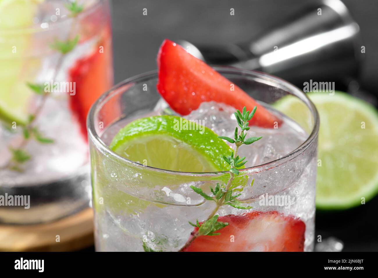 Mojito, margarita, daiquiri. Deux verres avec boisson fraîche au soda aux fraises, glaçons, thym et outils barman sur dar Banque D'Images