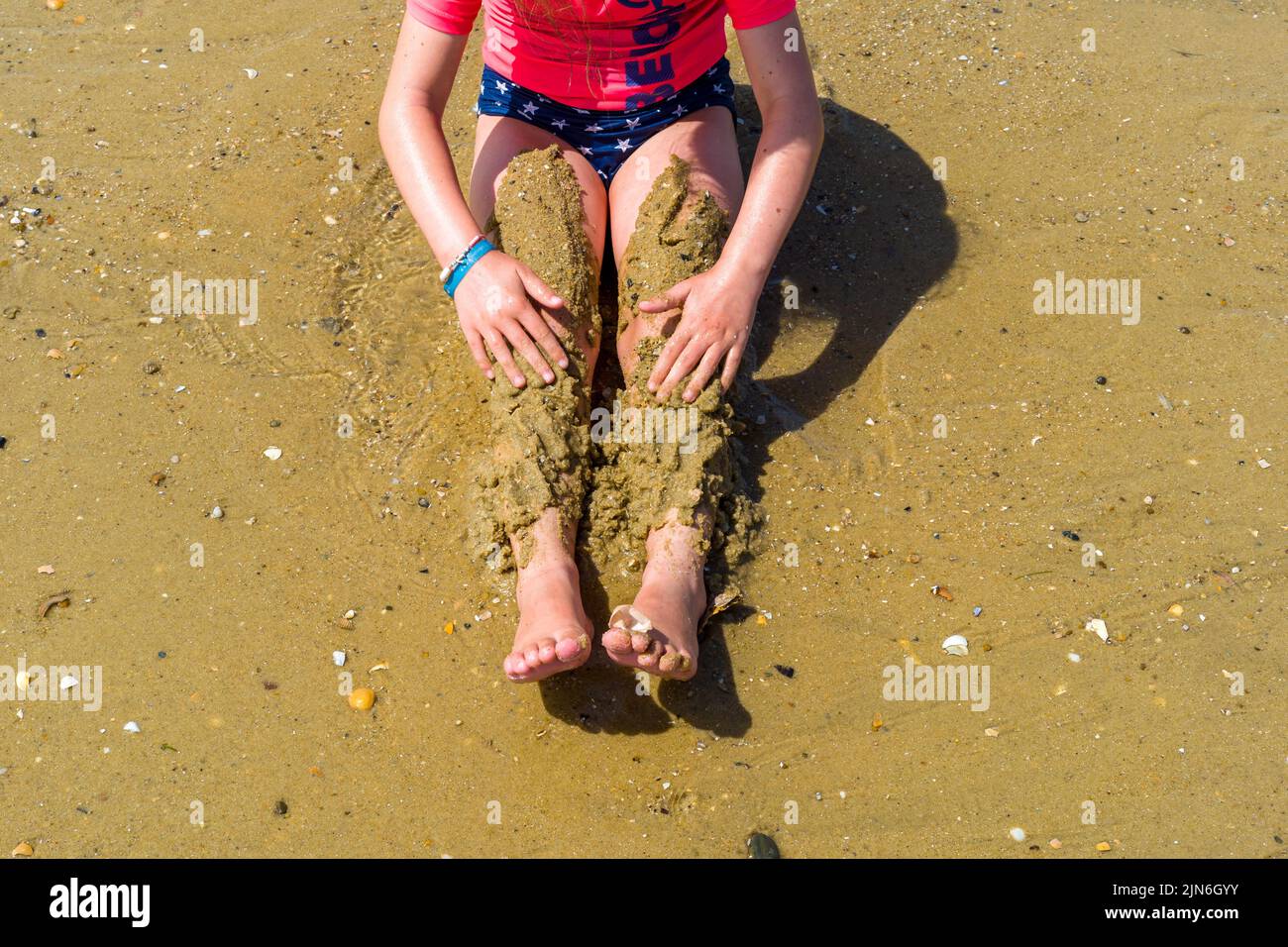 Une jeune fille sur la plage, jouant avec le sable sur ses jambes. La plage d'Arcachon, le quai Belisaire, les embarquements, les amoureux, les baigneurs, une journée à la plage. 04 août 2022. Photo de Patricia Huchot-Boissier/ABACAPRESS.COM Banque D'Images