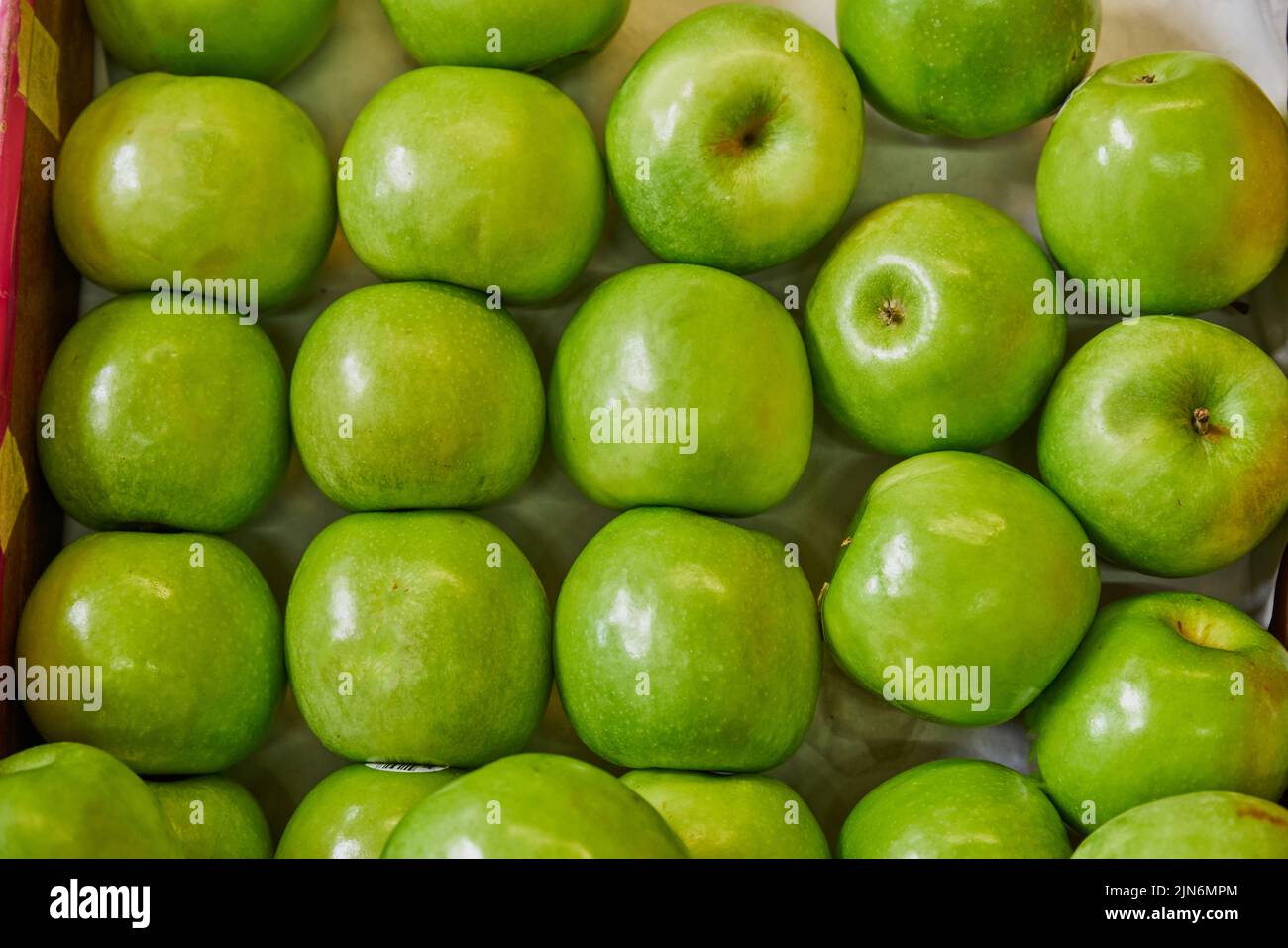 Pommes vertes placées sur une étagère pour la vente sur un marché Banque D'Images