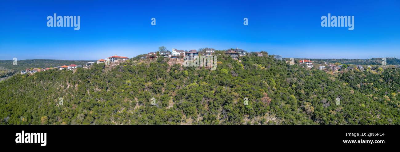 Vue panoramique d'un quartier résidentiel au sommet d'une montagne à Austin, Texas. Il y a des arbres sur la pente avec de grandes maisons sur le dessus contre le Banque D'Images